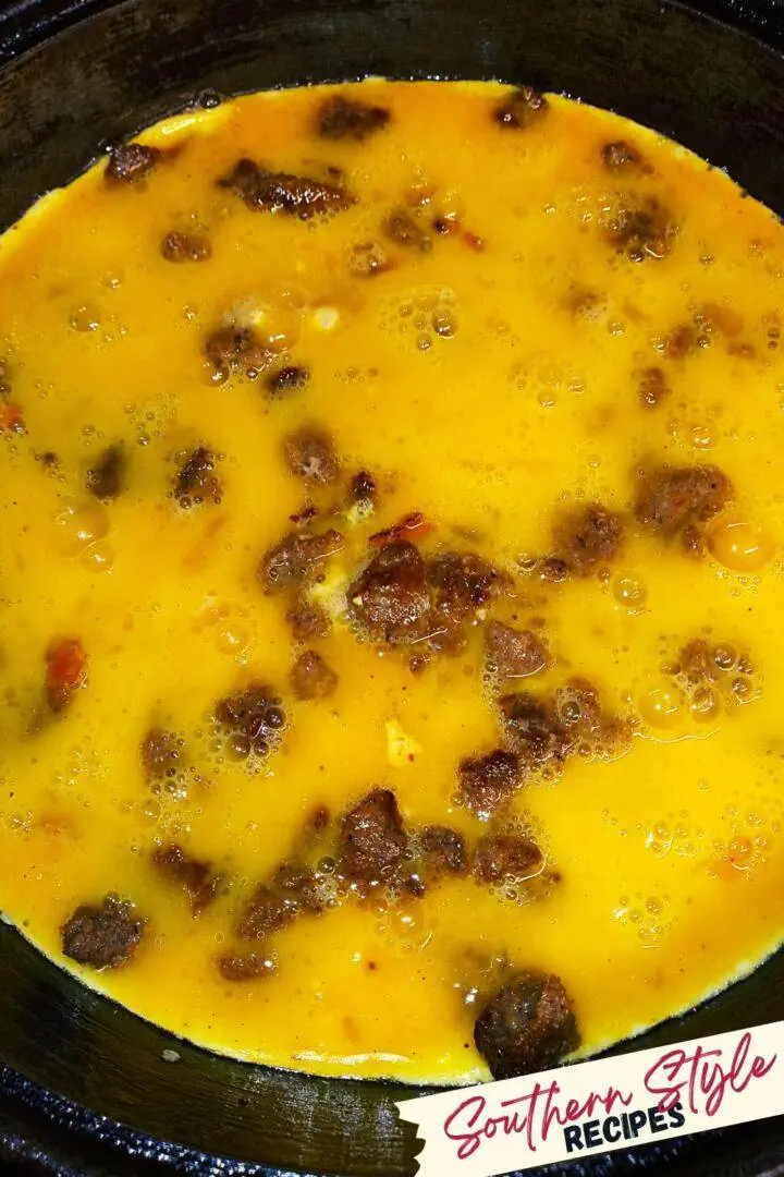 meat crumbles covered with uncooked scrambled eggs
